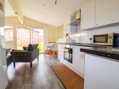 A kitchen with a dining area and sofa at H2 Atlantic Bay Holiday Park in Padstow
