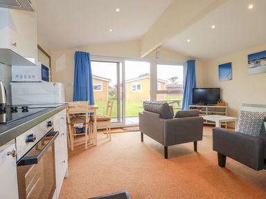 A living room with a sofa and dining area at 161 Atlantic Bay Holiday Park Padstow