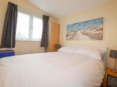 A bedroom with a bed and a wardrobe at 161 Atlantic Bay Holiday Park, Padstow