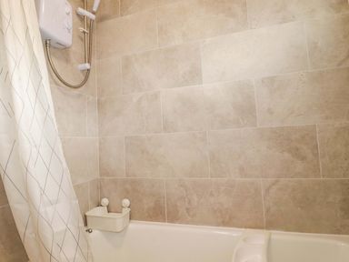A bathroom with a bath tub and a shower at 161 Atlantic Bay Holiday Park in Padstow