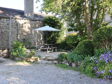 A garden with a picnic table and umbrella at The Little Farmhouse in Carnforth
