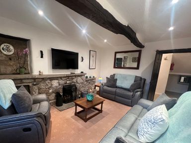 A living room with a television and seating area at The Old Farmhouse at Brackenthwaite Farm Yealand Redmayne near Arnside