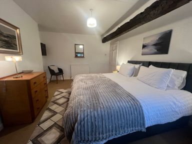 A bedroom with a bed and furniture at The Old Farmhouse at Brackenthwaite Farm Yealand Redmayne near Arnside