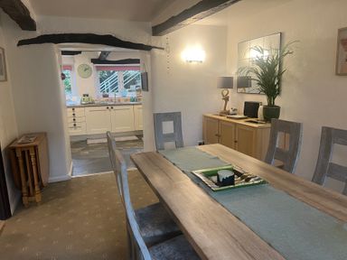 A dining room with a table and chairs at The Old Farmhouse at Brackenthwaite Farm Yealand Redmayne near Arnside
