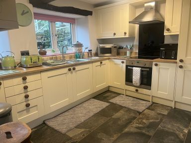 A kitchen with appliances and countertops at The Old Farmhouse at Brackenthwaite Farm Yealand Redmayne near Arnside