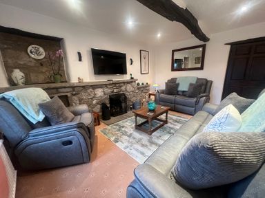 A living room with sofas and a coffee table at The Old Farmhouse at Brackenthwaite Farm Yealand Redmayne near Arnside