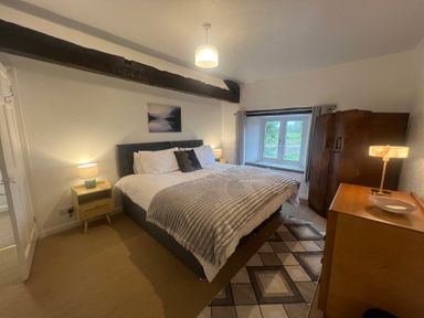 A bedroom with a double bed and window at The Old Farmhouse at Brackenthwaite Farm Yealand Redmayne near Arnside
