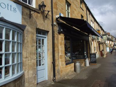 A street with stone buildings shops and a sidewalk at Cherry Blossom Cottage in Stratford-Upon-Avon