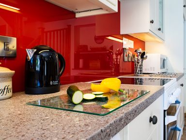 A kitchen countertop with a black electric kettle sliced zucchini and a yellow bell pepper at Teifi Cottage Cardigan Near Cenarth