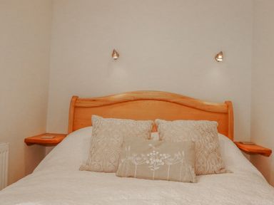 A bedroom with a bed and pillows at Poldue House Watergate near Camelford
