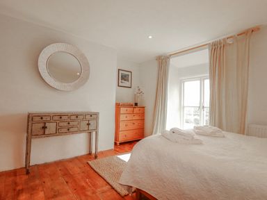 A bedroom with a bed and dresser at Poldue House Watergate near Camelford