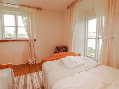 A bedroom with two beds and a window at Poldue House Watergate near Camelford