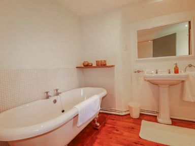 A bathroom with a bathtub and sink at Poldue House Watergate near Camelford
