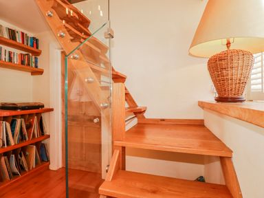 A staircase with a bookshelf and lamp at Roughtor Barn Poldue near Camelford