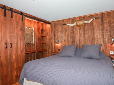 A bedroom with a bed and wooden shelves at Roughtor Barn Poldue near Camelford