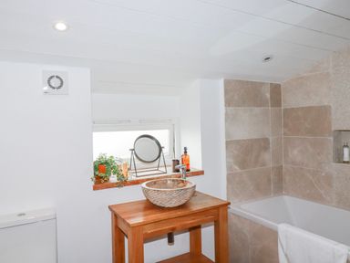 A bathroom featuring a wash basin, toilet, and bathtub at Roughtor Barn Poldue near Camelford