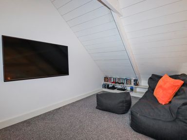 A snug room with a TV and bean bag chair at Roughtor Barn near Poldue near Camelford