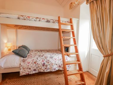 A bedroom with a bunk bed and a wooden ladder at Roughtor Barn Poldue near Camelford