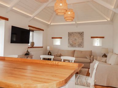 A living room with a sofa and television at Logan Barn near Camelford