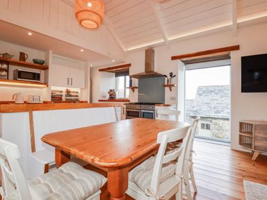 A kitchen with a dining table and chairs at Logan Barn in Poldue near Camelford