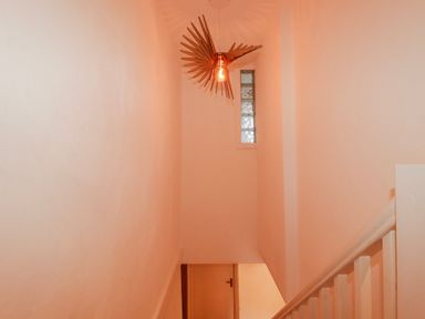 A hallway with a staircase and light fixture at Logan Barn Poldue near Camelford