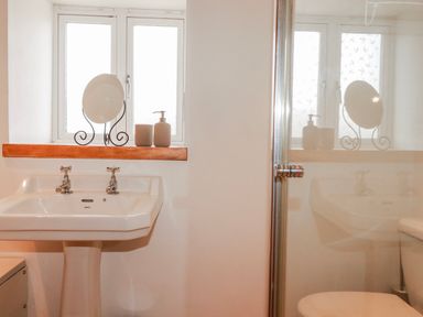 A bathroom with a washbasin and window at Logan Barn near Camelford