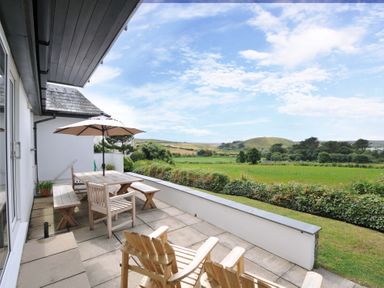 An outdoor area with a table and chairs at Seaworthy in Daymer Bay