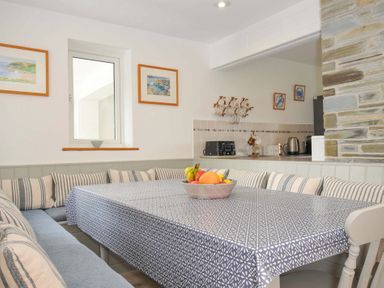 A dining room with a table and fruit bowl at Seaworthy in Daymer Bay