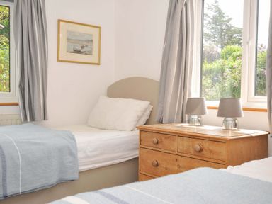 A bedroom with two beds and a dresser at Seaworthy in Daymer Bay