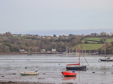 Boats on a river with houses and trees on the hills in the background at Alpha Cottage in Dittisham near Dartmouth
