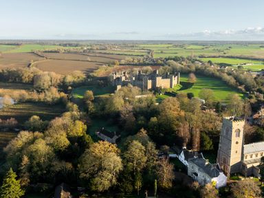 An aerial view of a castle and church surrounded by fields at 5 St. Michaels Close Framlingham