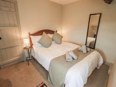 A bedroom with a bed and towels on it at Old Cottage in Oxen Park near Ulverston