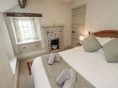 A bedroom with a bed and towels on the bed at Old Cottage in Oxen Park near Ulverston