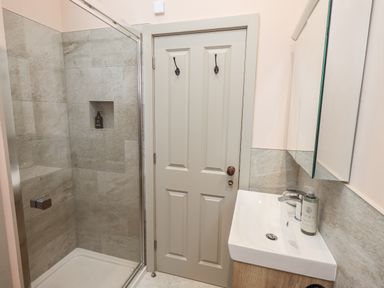 A bathroom with a shower and sink at Old Cottage in Oxen Park near Ulverston