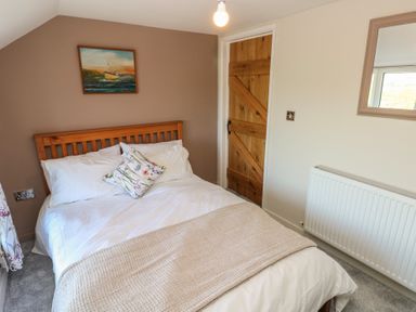 A bedroom with a bed a wooden door a radiator and a painting at Chapel Hill House in Chapel Hill near Pembroke