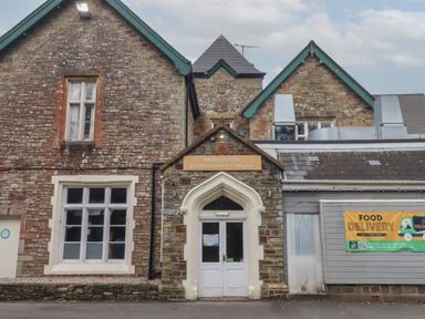 The entrance of Manor House Entertainment Complex with stone walls and a food delivery sign at Bucks Cross Bideford
