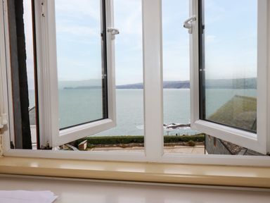 An open window overlooking the sea and coastal landscape at Blue Horizon in Port Isaac