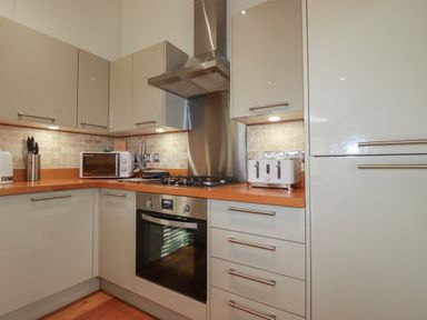 A kitchen with a built-in oven stove microwave toaster knife block and cabinets at 3 Hedgerows in Lanreath