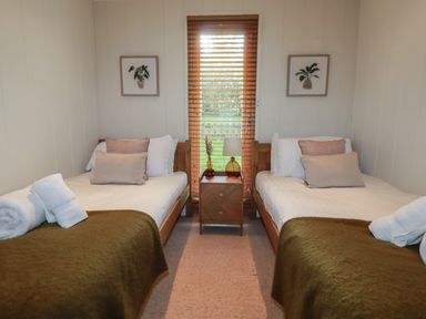 A bedroom with two beds a nightstand and window blinds at 3 Hedgerows in Lanreath