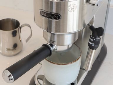 An espresso machine with a coffee cup and milk jug at Little Victory in Pendeen