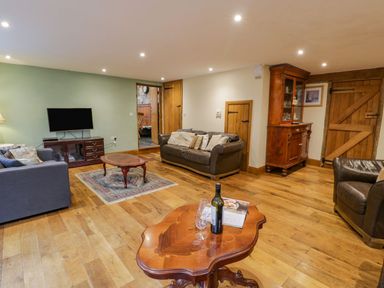 A living room with sofas a coffee table a television and wooden furniture at Ysgubor in Dinas Mawddwy near Dolgellau
