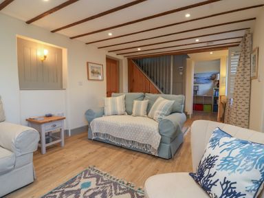 A living room with sofas cushions and a wooden floor at Curlew Cottage in North Curry near Taunton