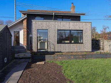 A wooden house with large windows a garden shed and a grass lawn at Curlew Cottage North Curry near Taunton