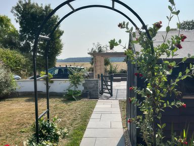 A garden with an arch entrance and pathway at Curlew Cottage North Curry near Taunton