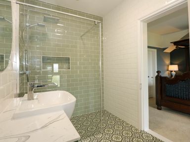 A bathroom with a sink and walk-in shower and a view of a bedroom at Fir Grove in Menai Bridge