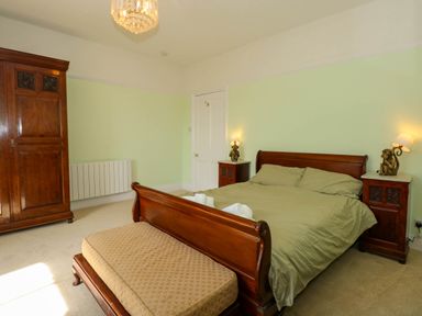 A bedroom with a wooden bed and matching furniture at Fir Grove in Menai Bridge