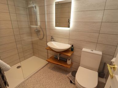A bathroom with a shower, sink, and toilet at Bramble Cottage in Thornthwaite near Braithwaite