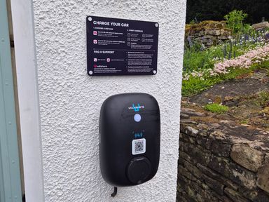 A charging station with instructions and QR code at Bramble Cottage in Thornthwaite near Braithwaite
