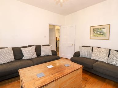 A living room with two sofas with patterned cushions and a wooden chest used as a coffee table at Middletown in Keswick