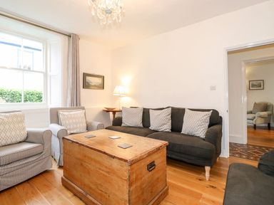 A sitting room with a dark sofa and patterned armchairs around a wooden chest at Middletown in Keswick